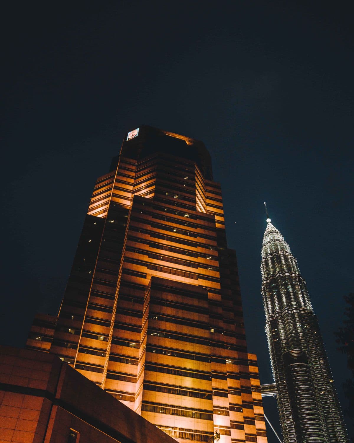 Kuala Lumpur towers lit at night against a dark sky.